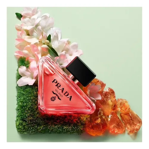 Prada Paradoxe red bottle on grass with flowers and amber crystals